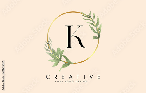 K Letter logo design with golden circles and green leaves on branches around. Vector Illustration with K letter.