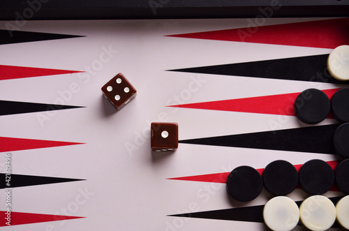 View from the top to the playing field in backgammon with chips and dice brown. Play a board game. High quality photo