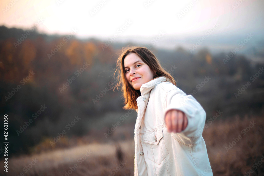 Beautiful portrait of a young stylish woman on a sunny day in autumn.