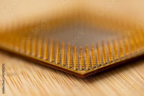 Close-up of a processor's pins on a wooden table. Selective focus.