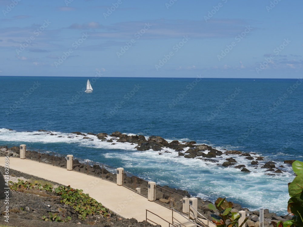 Rocky coastal area  with foaming waves at the walkway behind the