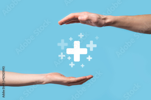 Male hand holding plus icon on blue background. Plus sign virtual means to offer positive thing (like benefits, personal development, social network)Profit,health insurance, growth concepts