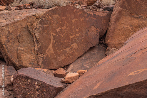 Prehistoric Bushman engravings, rock painting at Twyfelfontein, Namibia - Lion Plate and other animals and symbols photo