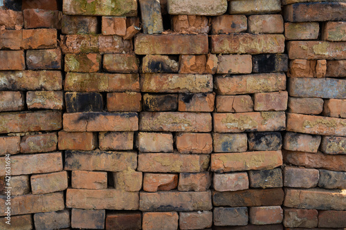 A pattern of old red brick blocks all stacked together. Many vintage broken dirty bricks stacked together into the wall, background texture for interior and exterior design, wide horizontal banner.