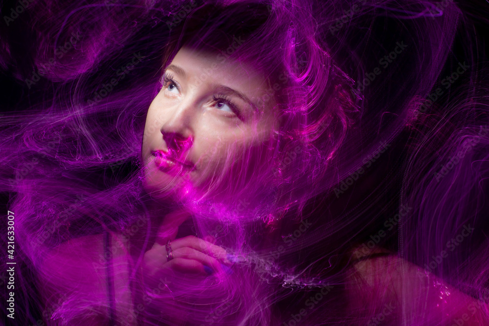 beautiful girl model with cosmic make-up on face, blue and purple color on dark background , longexposure foto