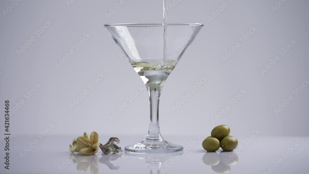 Making an alcoholic martini drink. Vermouth is poured into a glass and then throw the olive. 4K video slow motion of a beautiful alcoholic composition in a bar or restaurant. Making an alcoholic martini drink. Vermouth is poured into a glass and then throw the olive. 4K video slow motion of a beautiful alcoholic composition in a bar or restaurant.