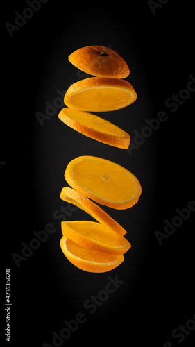 Orange Fruit Cut into Slices on a Black Background