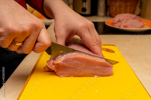 Obraz na płótnie pork chop cutting process on a yellow notch