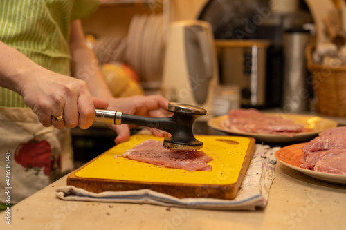 pork chop tenderize with a meat hammer in real kichen photo