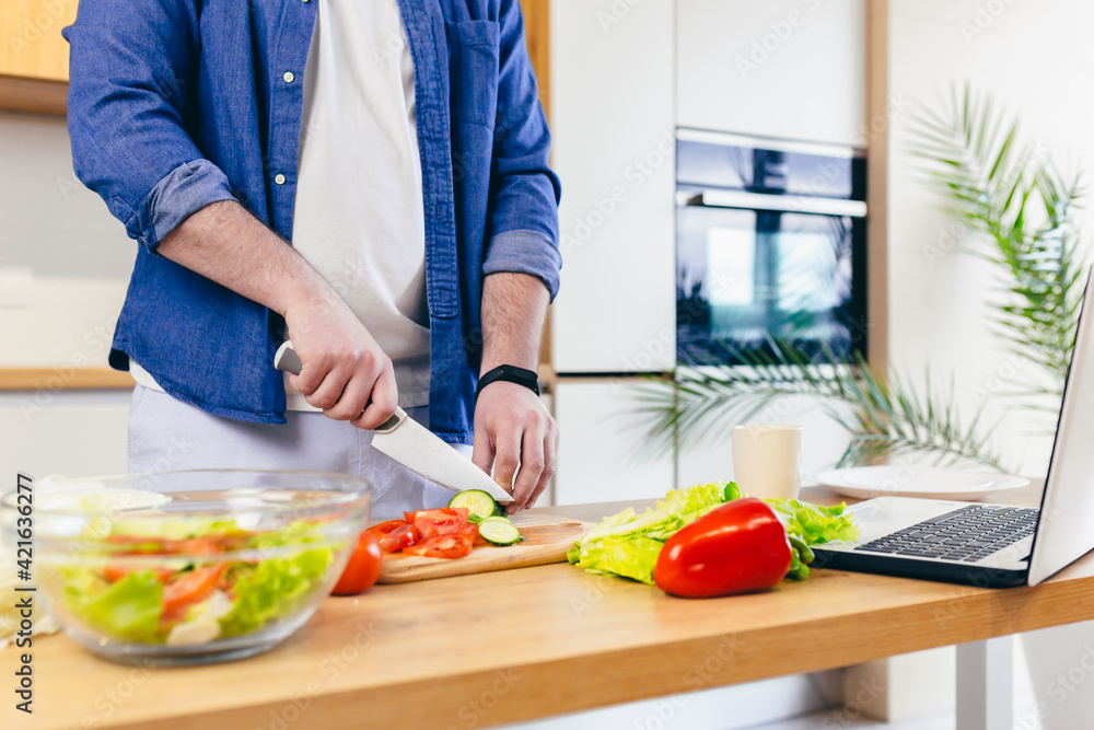 Close-up photo, a man at home chops vegetables in the kitchen, prepares breakfast Close-up photo, a man at home chops vegetables in the kitchen, prepares breakfast