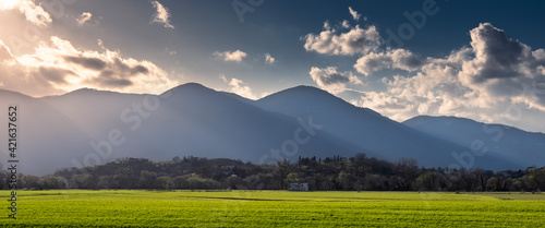 ultime luci del giorno sulla piana di rieti vista dal lago di ripasottile. campi verdi illuminati dai raggi caldi del sole