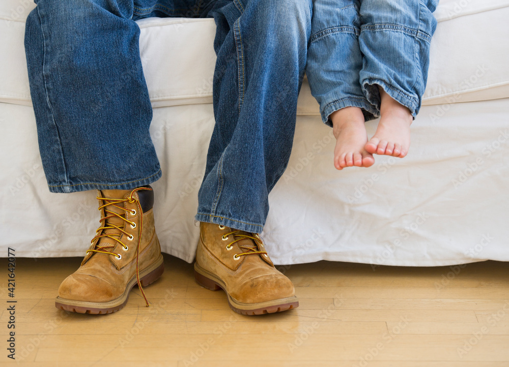 Legs of two people sitting on couch Legs of two people sitting on couch