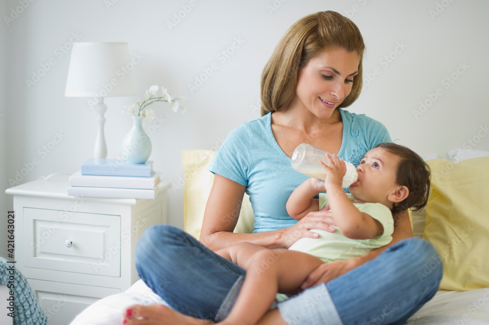 Mother feeding baby daughter (12-18 months) Mother feeding baby daughter (12-18 months)