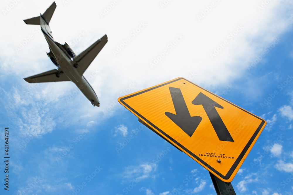 Airplane flying above down traffic sign Airplane flying above down traffic sign