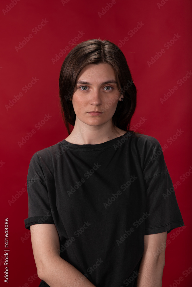 tired exhausted long-haired brunette girl In black T-shirt posing looking stressed and nervous at camera on red studio backdrop. anxiety, Call Center for Women problems, gender discrimination concept tired exhausted long-haired brunette girl In black T-shirt posing looking stressed and nervous at camera on red studio backdrop. anxiety, Call Center for Women problems, gender discrimination concept
