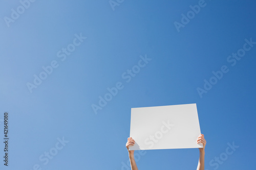 Arms holding a blank placard