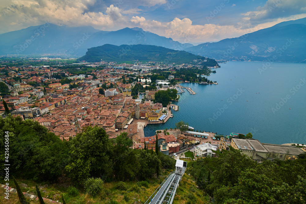 Riva del Garda ,Italy - 07 July  2020: Panoramic view of the beautiful Lake Garda and the Panoramic lift .Riva del Garda town and Garda lake in the autumn time , Trentino Alto Adige region,Italy