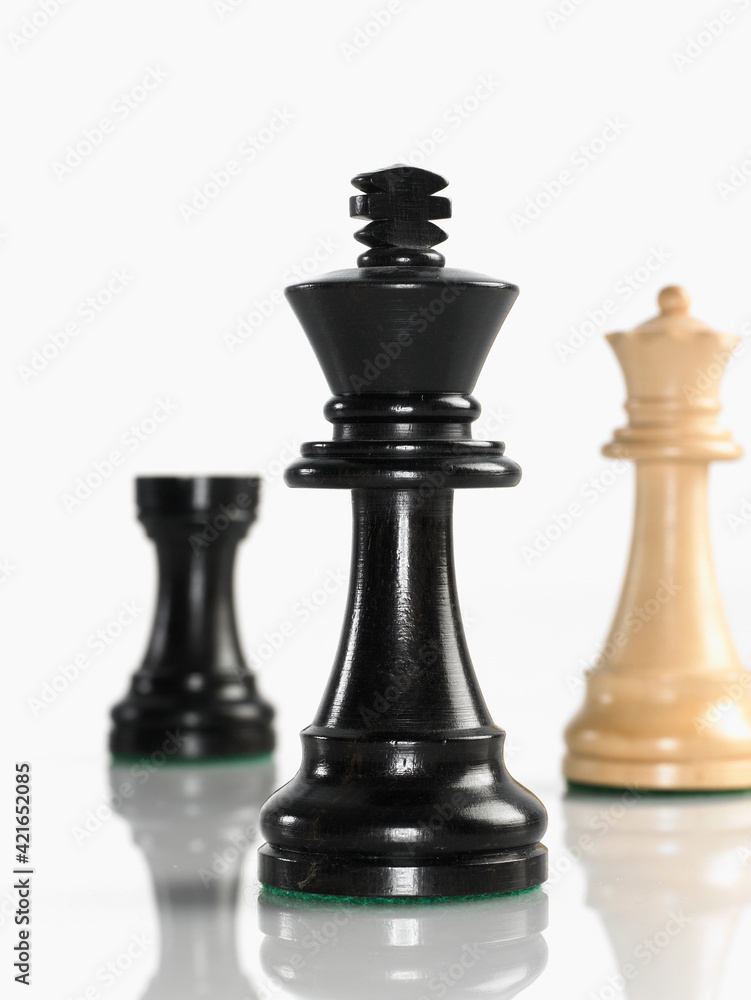 King chess piece with queen and rook in background King chess piece with queen and rook in background