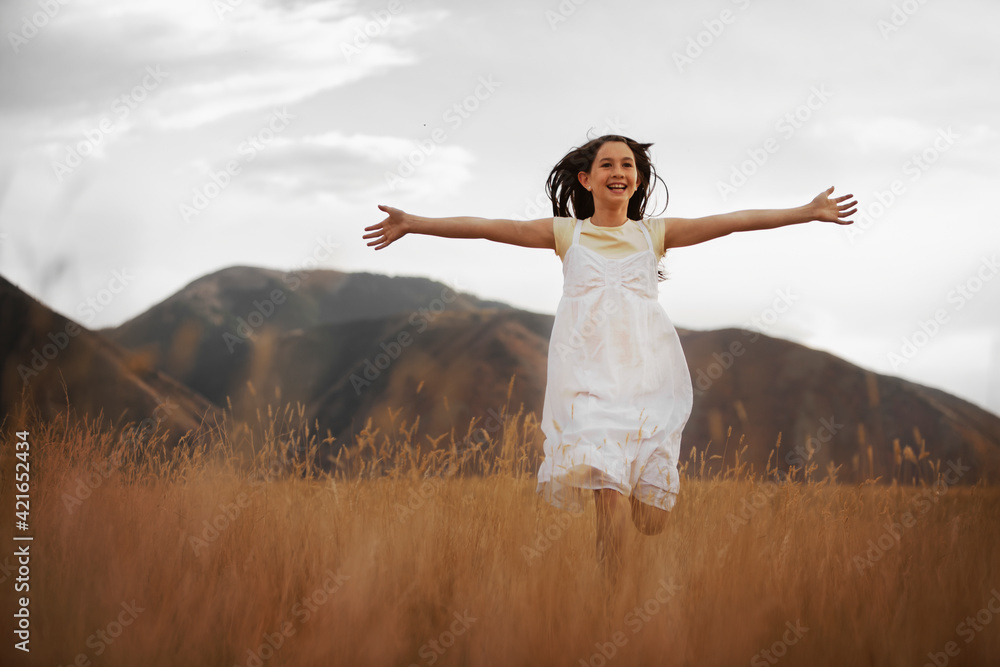 Girl (10-11) running through wheat field Girl (10-11) running through wheat field