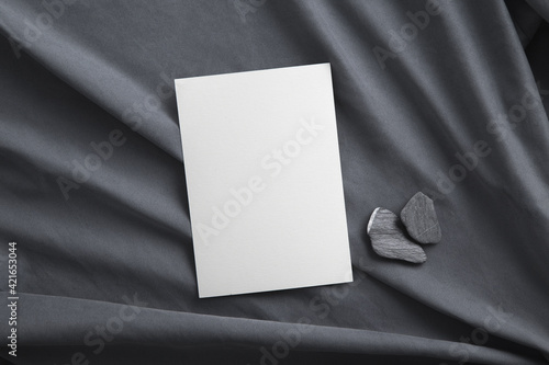 Blank greeting invitation card and grey stones. Mock-up.