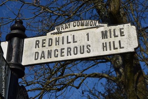 Old british rural signpost warning of dangerous hill
