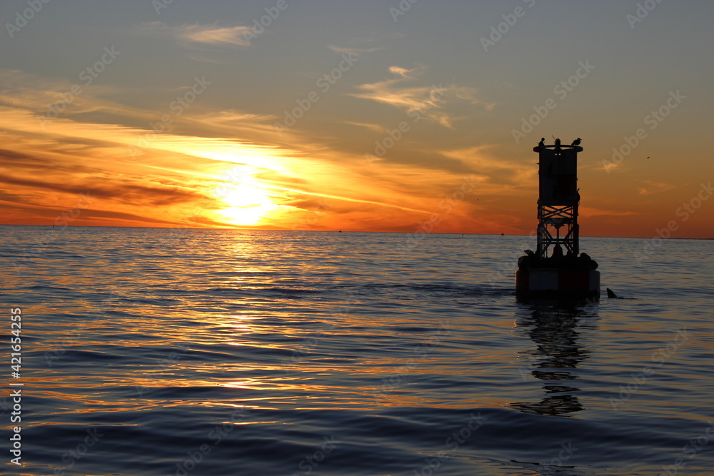 silhouette of a buoy at sunset