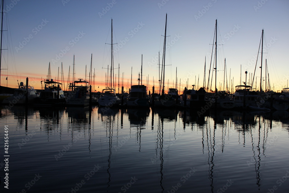 Boats at the dock in the harbor at sunset