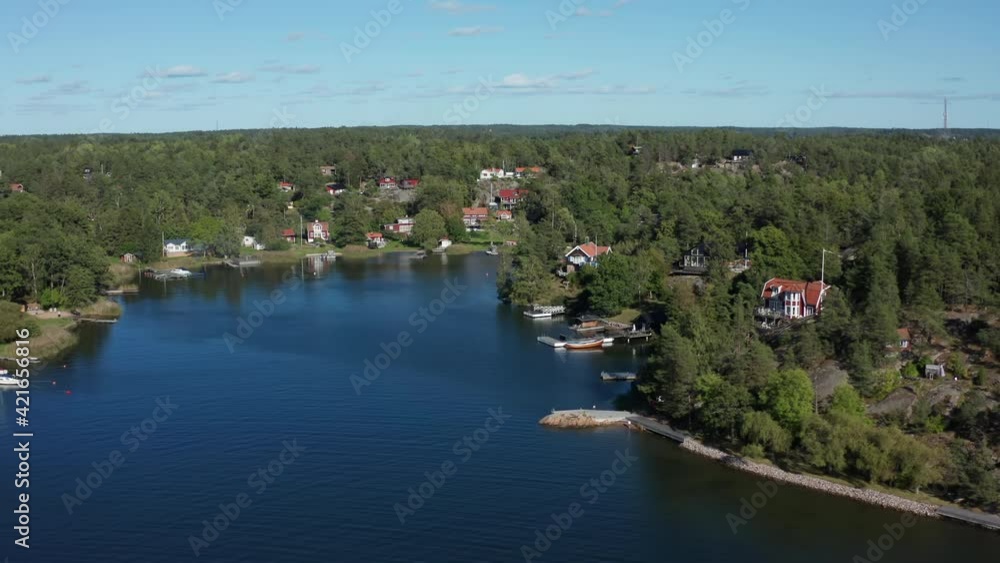 Picturesque quiet bay in Archipelago in Scandinavia, Northern Europe. Residential area with sailing boats. Summer day aerial flying over water and stone islands with boats, houses, villas, jetty, dock Picturesque quiet bay in Archipelago in Scandinavia, Northern Europe. Residential area with sailing boats. Summer day aerial flying over water and stone islands with boats, houses, villas, jetty, dock