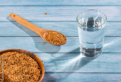 Spoon with fenugreek grains to mix with water - Trigonella foenum-graecum photo