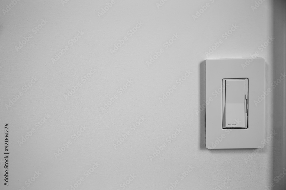 Single light switch dimmer on a white wall with space for text Single light switch dimmer on a white wall with space for text