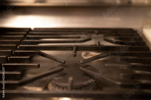 Close-up of kitchen gas stove. Gas ring burner with black steel panels