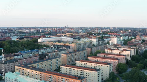 Summer evening in Södermalm, Stockholm, Sweden with City Hall in the background. Aerial drone view from above with rooftops, buildings, streets, and parks.