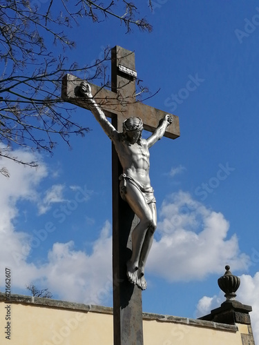 Fotografie Metal statue of the crucified Jesus on a wooden cross