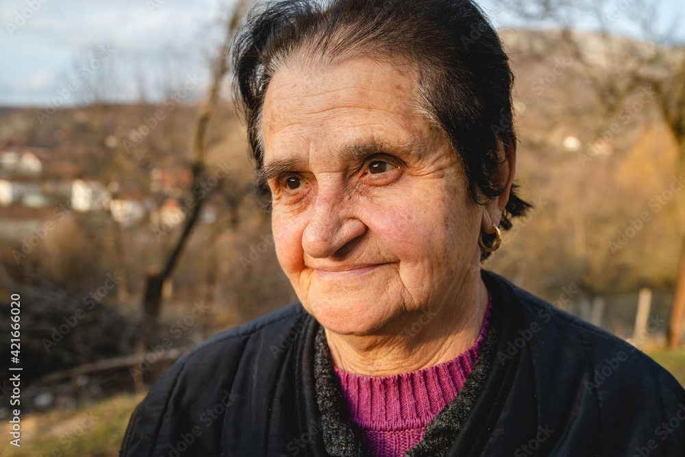 Portrait of senior caucasian woman in nature standing in spring or autumn day - close up of cheerful female pensioner farmer standing in rural nature on farm looking to the side - real people concept Portrait of senior caucasian woman in nature standing in spring or autumn day - close up of cheerful female pensioner farmer standing in rural nature on farm looking to the side - real people concept