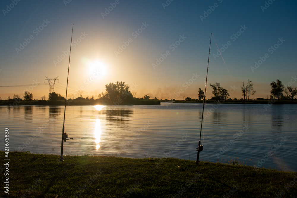 two fishing rods in beautiful river of Argentina at sunset with a beautiful landscape
