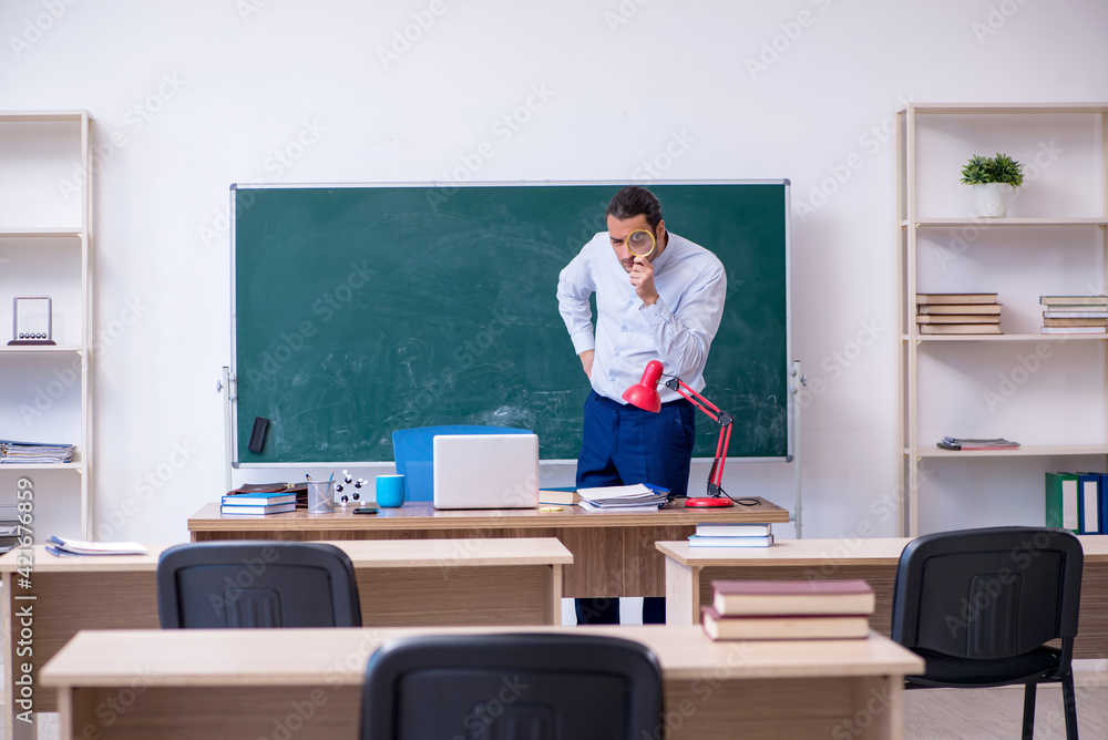 Young male teacher in front of green board Young male teacher in front of green board