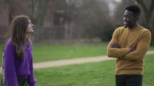Young woman flirting black man punching and teasing him. Interracial couple together
