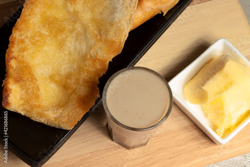 Traditional Brazilian  breakfast made with French bread toasted  (pão na chapa) with butter and milk with coffee (pingado). photo