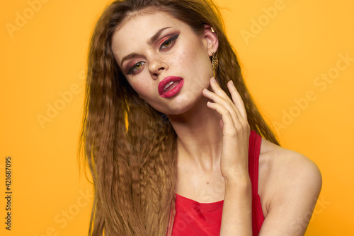 emotional woman wavy hair bright makeup lifestyle yellow background