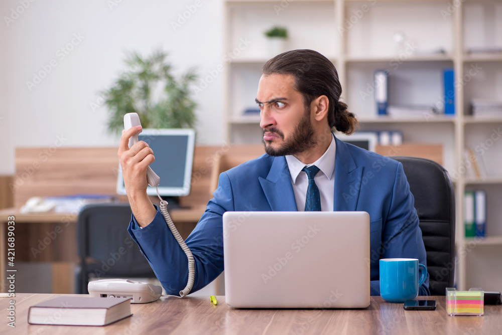 Young male employee working in the office Young male employee working in the office