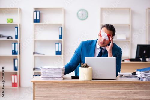 Blindfolded male employee working in the office