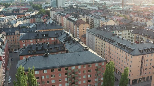 Stockholm, Sweden. Panoramic aerial drone flying over rooftop buildings with a view above SoFo, Nytorget, Skånegatan, Södermalm. Summer evening.