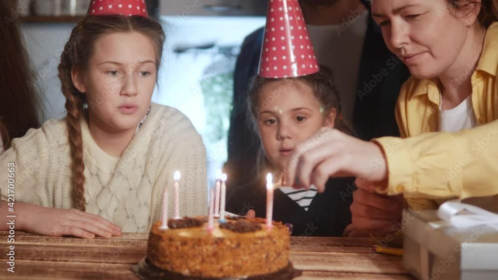 kid birthday. little girl blows out the candles on the cake in a circle of happy family. celebration birthday kid concept. friendly happy family celebrating birthday a lot dream of people kid birthday. little girl blows out the candles on the cake in a circle of happy family. celebration birthday kid concept. friendly happy family celebrating birthday a lot dream of people