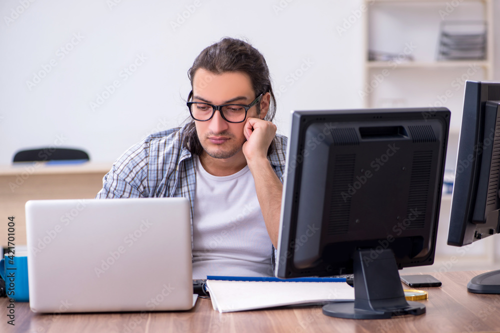 Young male it specialist working in the office Young male it specialist working in the office