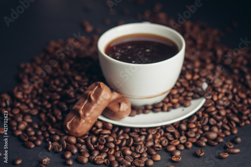 a cup of coffee and a chocolate bar on a saucer arabica beans variety drink
