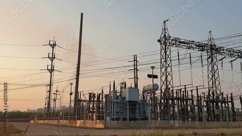 Electricity substation with green grass field in the morning light, Transmission line of electricity to rural field, Electricity tower with green nature landscape