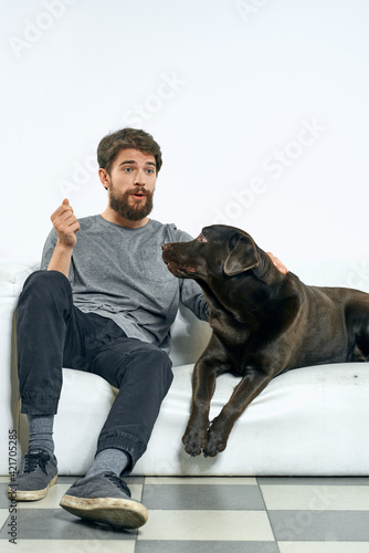 man at home on the couch with his dog resting friendship training © SHOTPRIME STUDIO