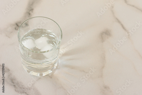 A glass of purified fresh drinking water on a marble table. copy space for text