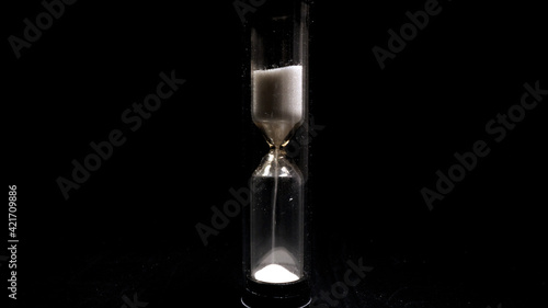 An hourglass in close-up on black blackground - probe lens close up shot