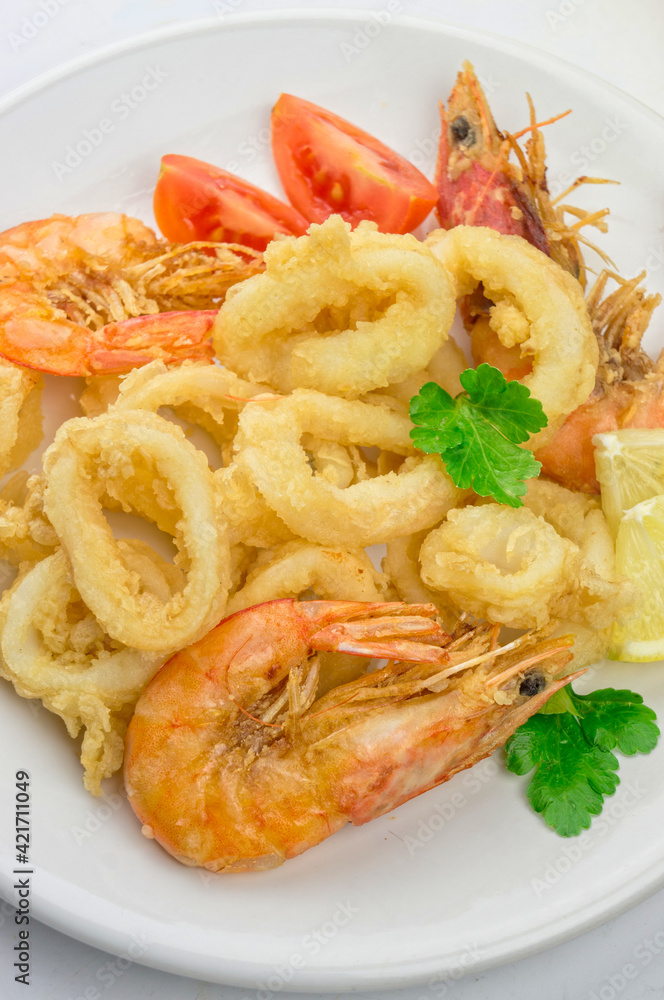 Fried calamari and shrimps on white plate Fried calamari and shrimps on white plate